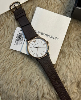 Emporio Armani watch with brown leather strap on a textured surface