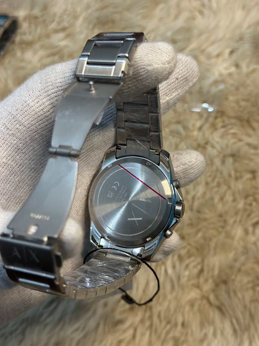 Silver watch with a textured strap held by a gloved hand on a beige background